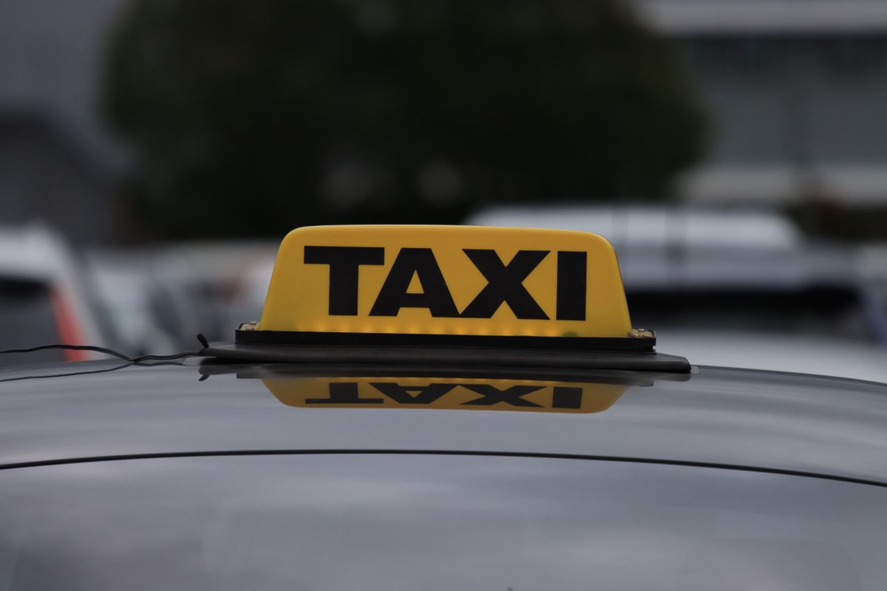 Mastering the First Impression: Your intriguing post title goes here Yellow taxi sign on a car roof in a city parking area during daylight.