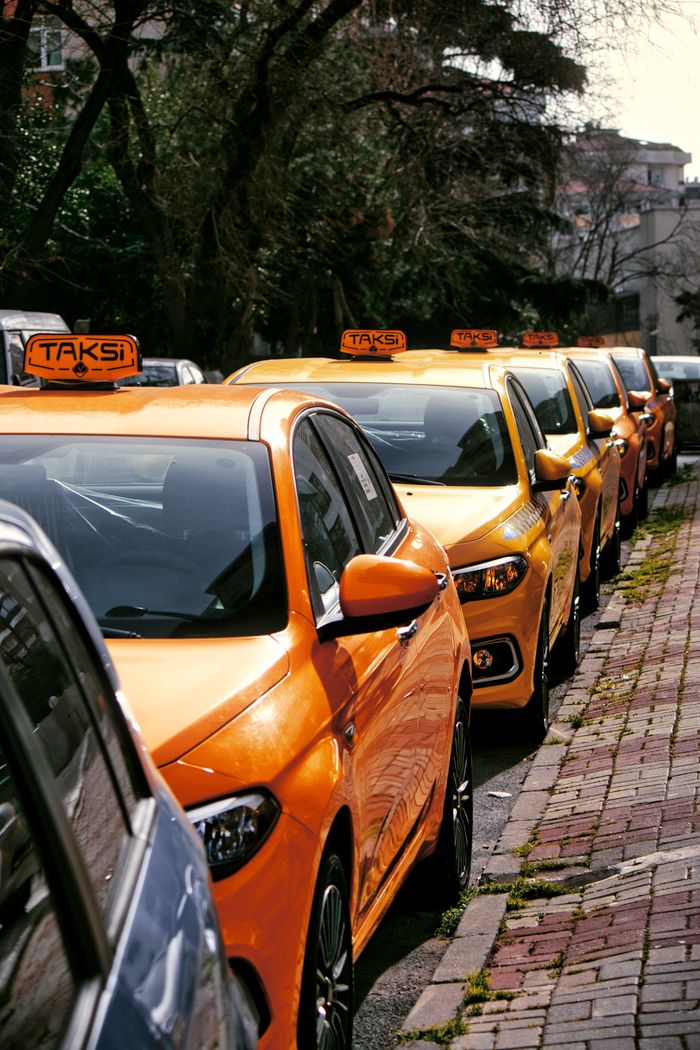 gallery-5 Close-up of multiple yellow taxis on a cobblestone street, hinting at lively urban transportation.
