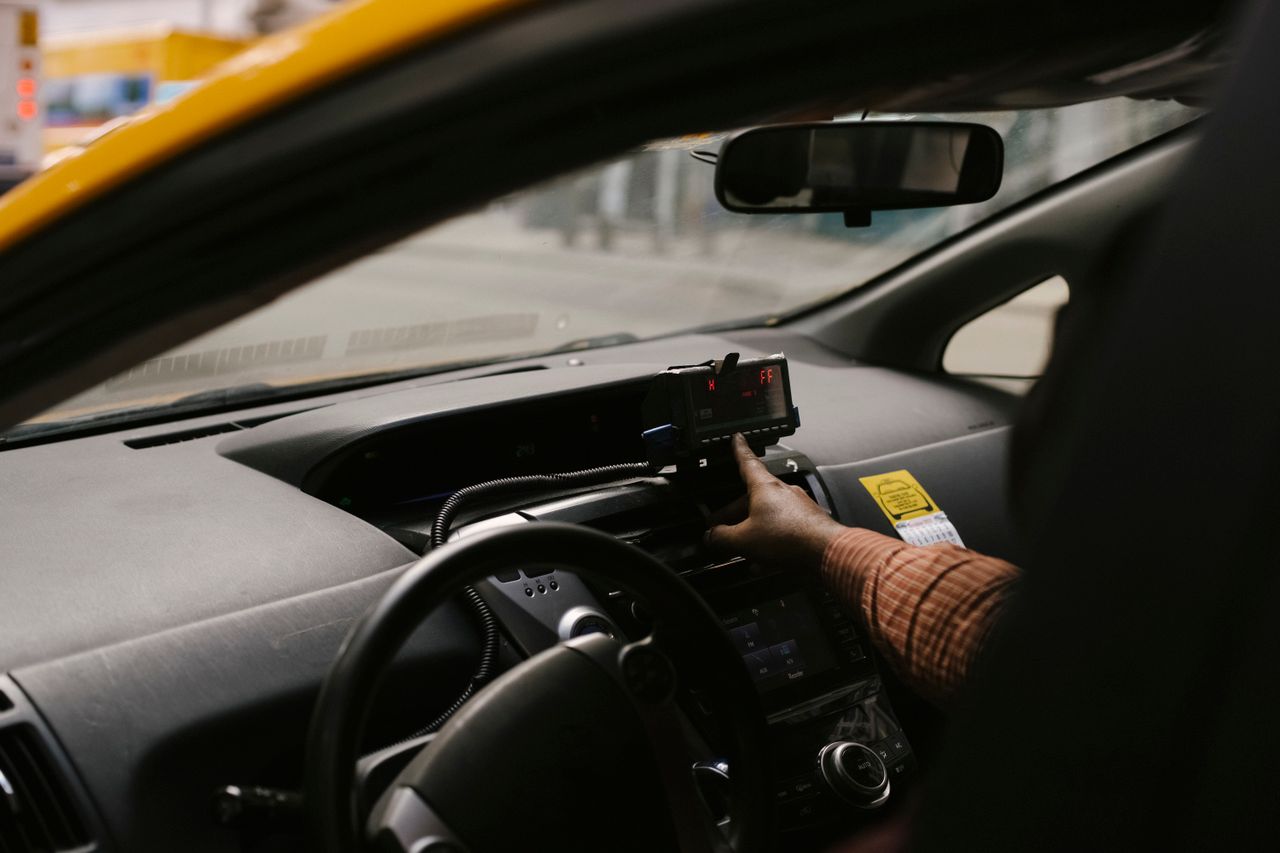 why-choose-us Anonymous ethnic male driver with steering wheel using GPS navigator to search direction for drive on street in city during work